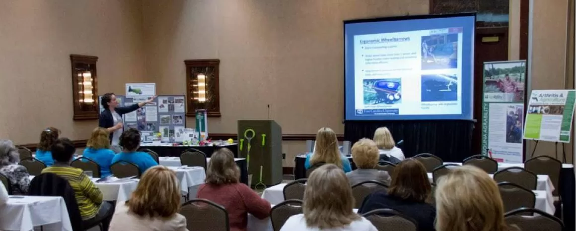 Indoor conference room with presenter showing a projection screen