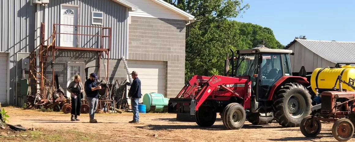 Men on a farm next to a tractor